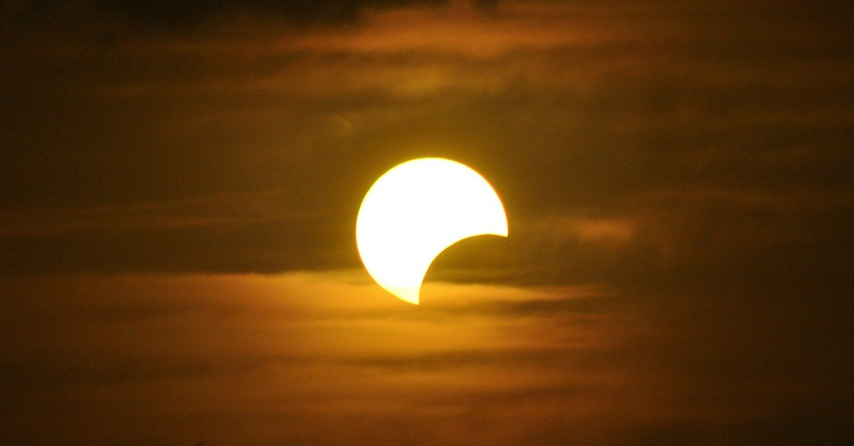 Foto de um eclipse solar, com a Lua encobrindo uma parte do Sol.