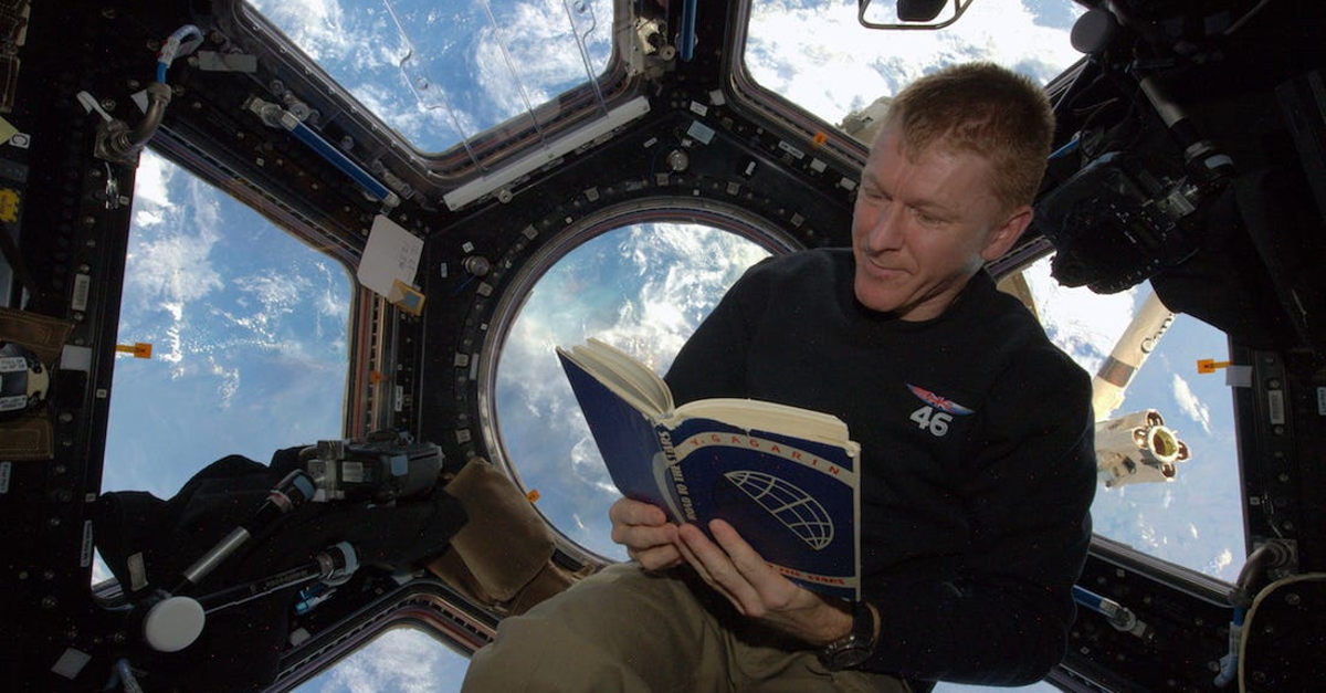 Foto do astronauta britânico Tim Peake lendo a bordo da Estação Espacial Internacional.
