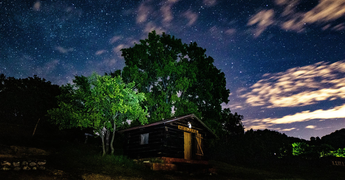 Céu noturno sobre uma cabana. Crédito da imagem