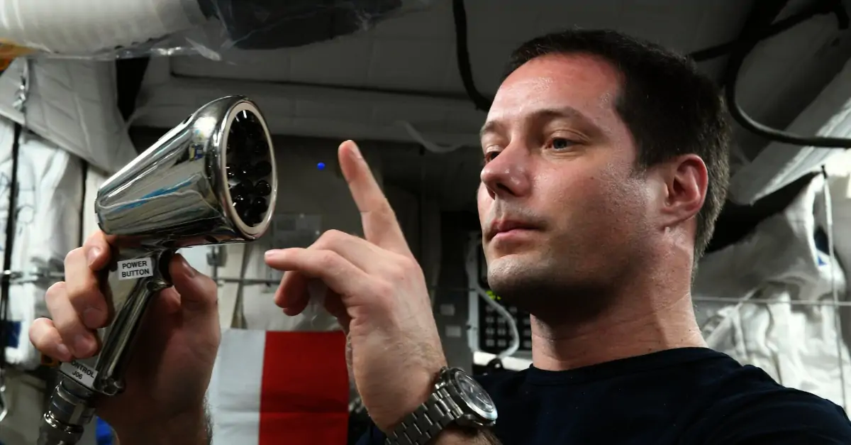 O astronauta Thomas Pesquet durante experimento com a pinça ultrassônica.