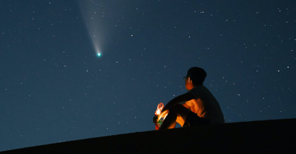 Menino observa a passagem de um cometa