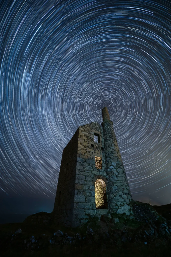 Vórtice © Jennifer Rogers (Reino Unido). Esta imagem de um rastro de estrelas alinhado com a chaminé da antiga mina de estanho Wheal Owles, na Cornualha, foi capturada em uma noite fria de fevereiro. Jennifer Rogers dedicou tempo para posicionar Polaris diretamente acima da chaminé na composição. Capturada com uma câmera Canon EOS 5D Mark IV, 14 mm f/2.8, ISO 1600. Primeiro plano: 1 exposição de 60 segundos; rastro de estrelas: 72 exposições de 60 segundos. Local: West Wheal Owles, Cornualha, Inglaterra, 22 de fevereiro de 2025.