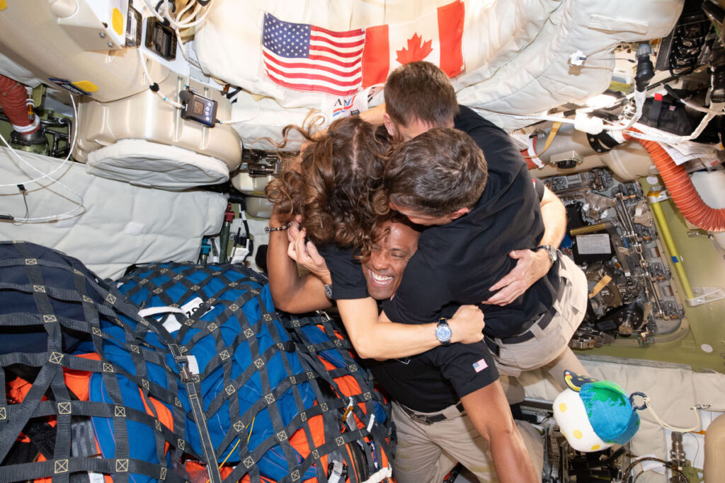 A tripulação da Artemis 2: Da esquerda:a astronauta da NASA Christina Koch, o astronauta da CSA (Agência Espacial Canadense) Jeremy Hansen, e os astronautas da NASA Reid Wiseman e Victor Glover, tiram um tempo para um abraço em grupo dentro da espaçonave Orion em 6 de abril de 2026.