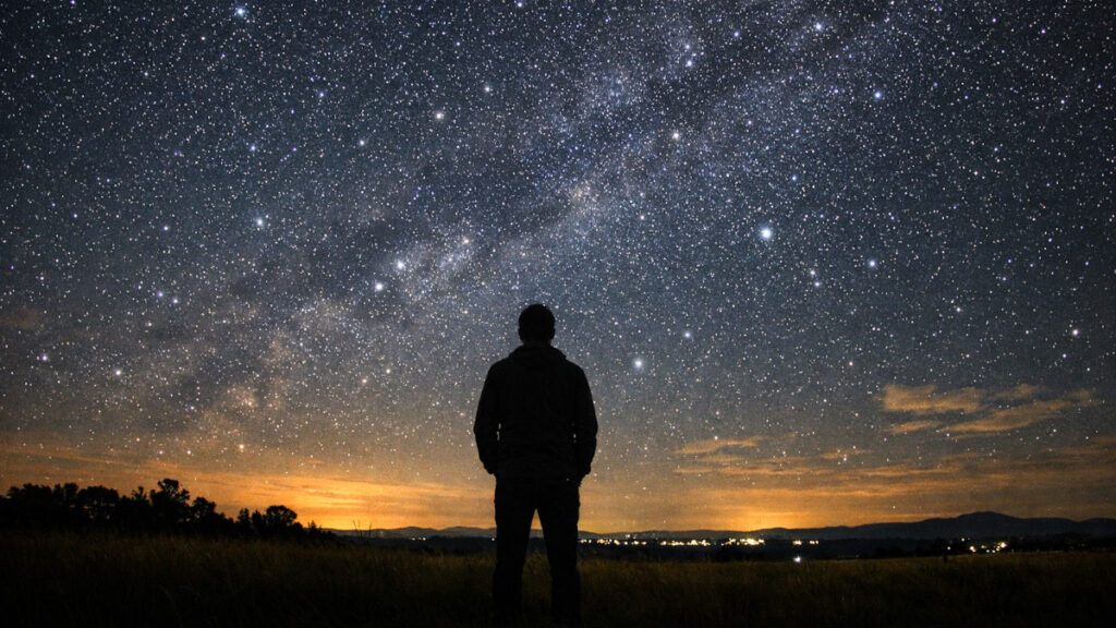 Pessoa observando o céu a olho nu em uma noite estrelada no Brasil
