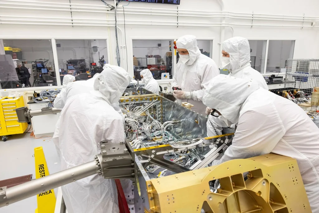 NASA define onde seu “drone” nuclear vai pousar em Titã 2 Engenheiros conectam seções de chicote elétrico de fiação a componentes dentro da Dragonfly da NASA em uma sala limpa no Laboratório de Física Aplicada Johns Hopkins, nos EUA (Crédito: NASA/Johns Hopkins APL/Ed Whitman)