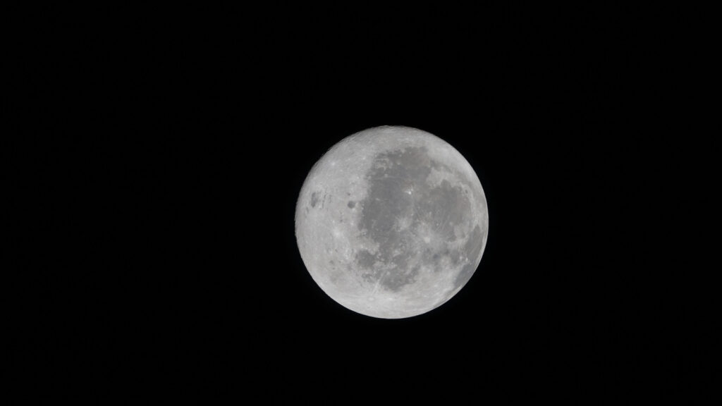 Uma vista do lado visível da Lua, captado pela missão Artemis 2. Parte do lado oculto também é visível na borda esquerda. (Crédito: NASA)