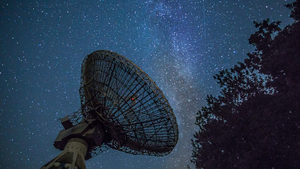 Antena parabólica sob o céu noturno. Imagem: Unsplash