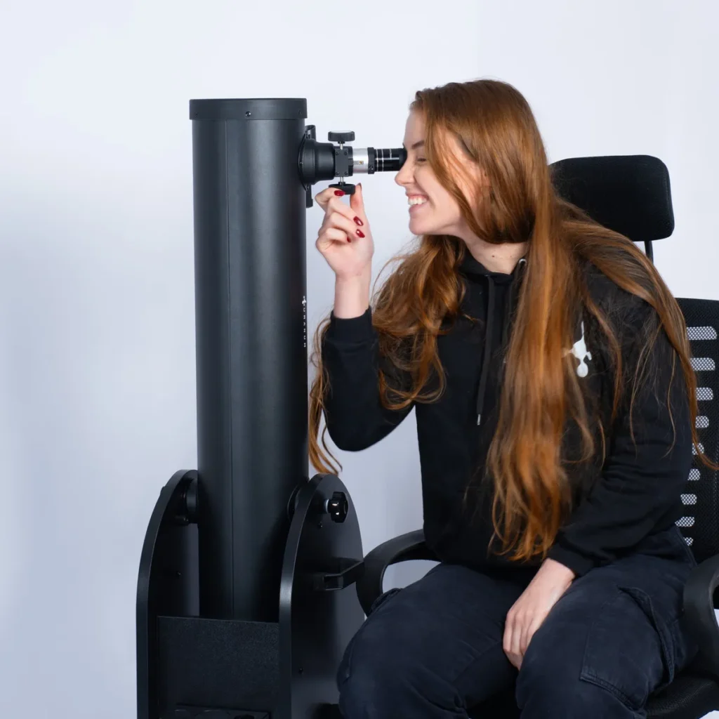 Foto de pessoa observando no telescópio da Uranum